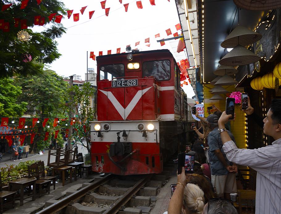 A large train going down Train Street in Hanoi, Vietnam on a Bunnik Tour to Vietnam